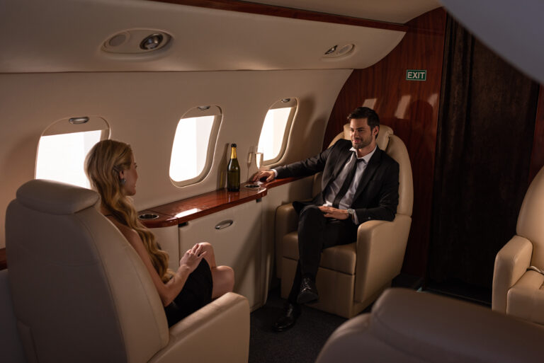 beautiful elegant couple drinking champagne while traveling in plane